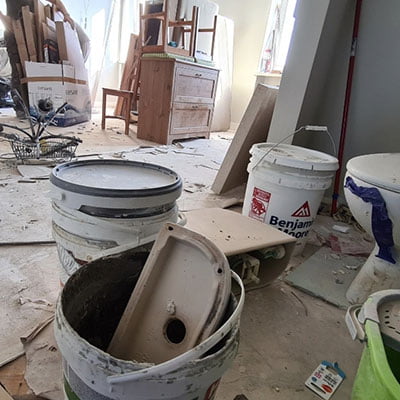 Sprzątanie poremontowe w dużym pomieszczeniu pełnym pyłu, odpadów poremontowych oraz kubłów z resztami farb