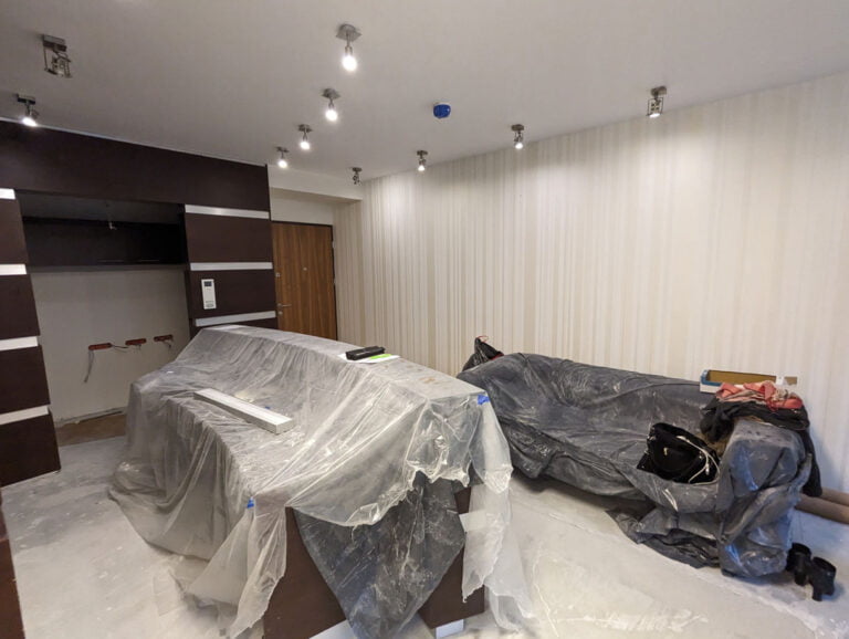 Wnętrze nowo wybudowanego domu Klienta Solid work czekające na sprzątanie. Meble przykryte folią