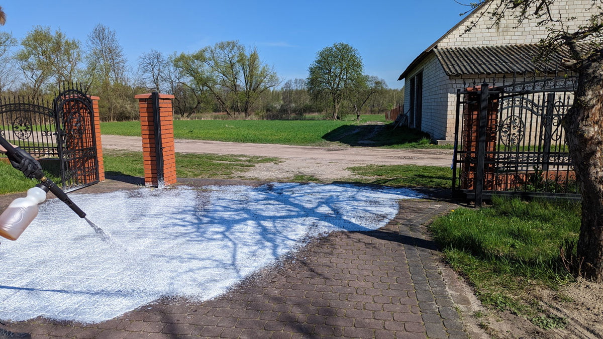 Czerwona kostka brukowa silnie zabrudzona w trakcie czyszczenia karcherem ze specjalną pianą