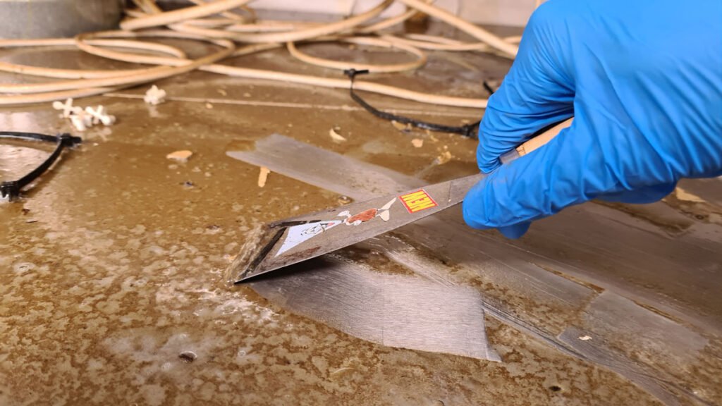 Profesjonalne zeskrobywanie przez pracownika Solid Work mocno zabrudzonej powierzchni blaszanej w obiekcie gastronomicznym