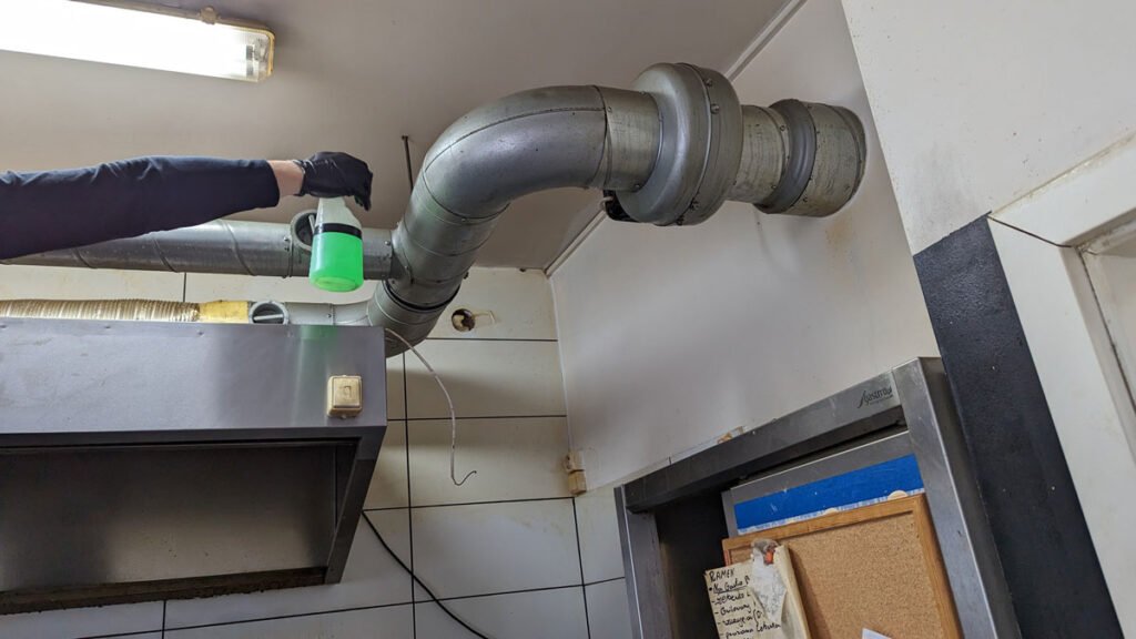 Profesjonalne sprzątanie przez pracownika Solid Work dużego elementu rur w obiekcie gastronomicznym