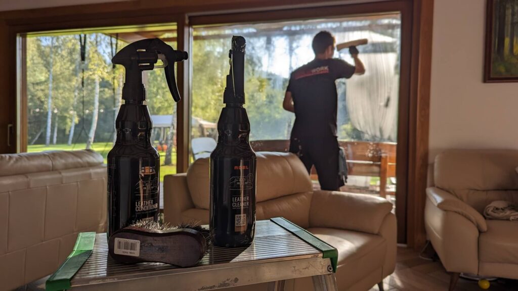 Pracownik firmy z napisem na koszulce Solid Work myje okno